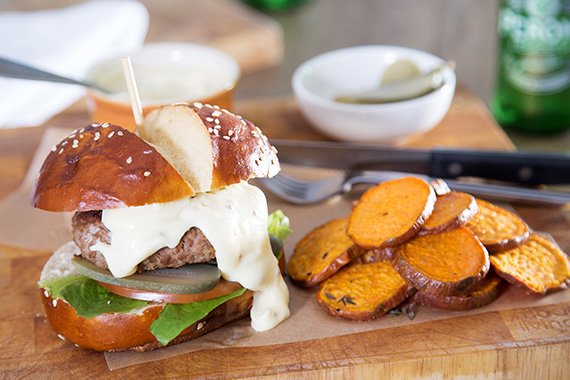 Beef Burgers on Pretzel Buns with Cheddar Sauce & Roasted Sweet Potato Rounds